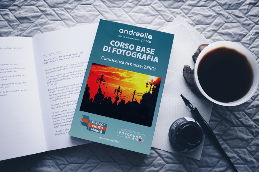 Il libro «Corso base di fotografia» su un tavolo, accanto a una tazza di caffè e a un calamaio